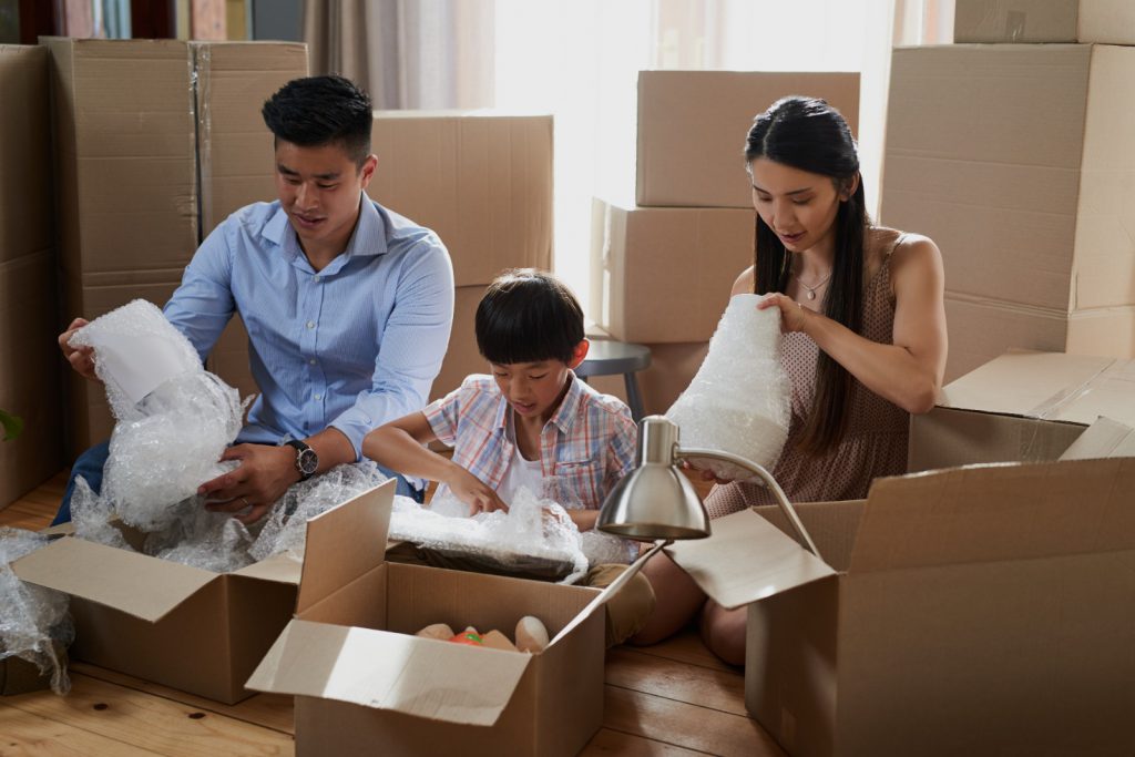 Family packing stuff on boxes for relocation